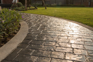 curved stamped concrete walkway with stone pattern and decorative border in landscaped backyard